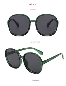 Detail view of retro oversized round sunglasses with translucent green frames and gray lenses.