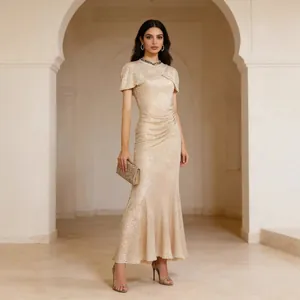 Full view of elegant champagne sequin evening gown with shawl sleeves and mermaid hemline.