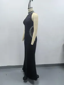 Vista lateral de un elegante vestido negro ajustado con cuello de perlas y aberturas.