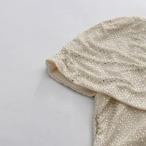 Detailed macro shot of elegant sparkling rhinestones on champagne mesh fabric sleeve