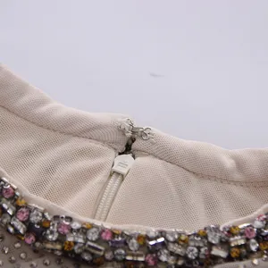 Macro detail of high-end round neck dress with intricate rhinestone embellishment