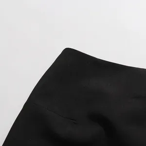 Gros plan sur la texture du tissu et les coutures d'une robe blazer noire asymétrique