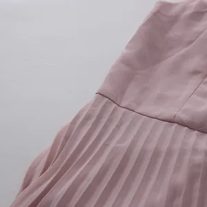 Detailed view showing the fine vertical pleats of an elegant dusty pink dress fabric