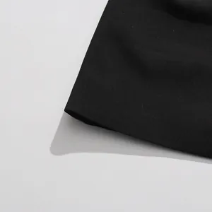 Gros plan détaillé montrant la texture du tissu et les coutures d'une robe de costume noire