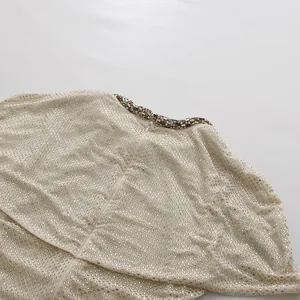 Close-up detail of luxury rhinestone embellishments on a beige designer evening dress