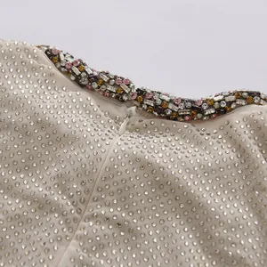 Close-up detail of rhinestone dress with colorful gemstone collar and hidden zipper