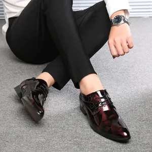 Glänzende burgunderrote und schwarze Herren-Lederhalbschuhe mit Schnürung im Detail.
