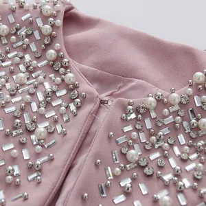 Close-up of elegant pink dress collar with heavy beadwork and rhinestone detailing