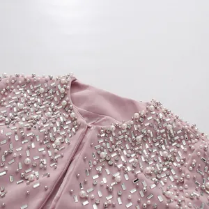 Close-up of heavy pearl and rhinestone embellishments on an elegant pink fabric