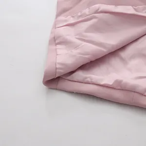 Close-up detail of the smooth inner lining and textured outer fabric of a pink skirt.