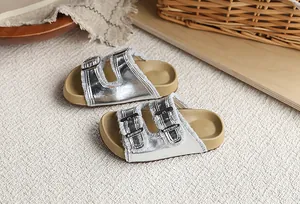 Primer plano de sandalias tipo Birkenstock plateadas para niña con hebillas