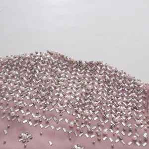 Macro detail of luxury pink dress featuring intricate pearl and rhinestone beadwork