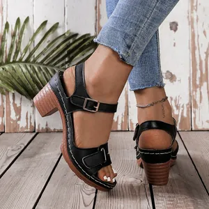 Detail view of black peep-toe sandals with chunky wood-textured heels.