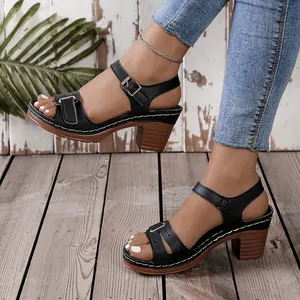 Detailed side view of black Roman style sandals with block heels and velcro straps.