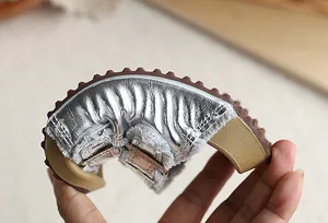 Primer plano de la suela flexible de chancla plateada tipo Birkenstock para niños y niñas