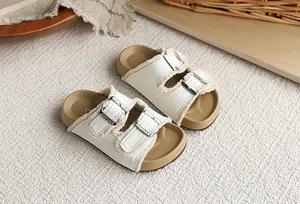 Detalle de sandalias tipo Birkenstock para niños en blanco con pelo y hebillas metal