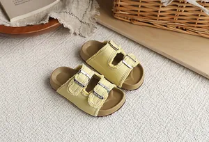 Primer plano detallado de sandalias de mezclilla amarillas para niños con hebillas dobles