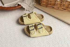 Primer plano de sandalias amarillas estilo Birkenstock para niñas con bordes deshilachados