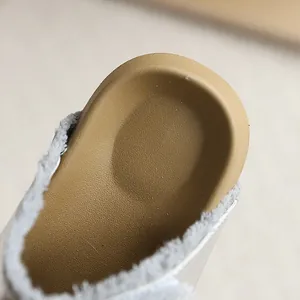 Primer plano de pantuflas infantiles estilo Birkenstock con forro de felpa gris suave