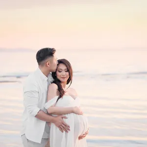 Elegant white off-shoulder maternity photography dress for romantic beach photoshoots