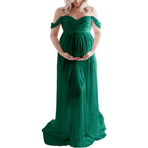 Full-length view of an elegant off-the-shoulder green maternity dress for photography sessions.