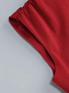 Close-up detail of the vibrant red fabric and stitching on a sleeveless party dress