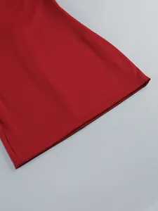 Macro detail of the stitched hemline of a deep red bodycon evening gown party dress