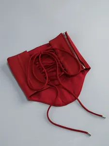 Detailed view of a red lace-up corset belt featuring a functional silver zipper and ties