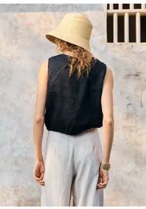 Achteraanzicht van zwart mouwloos casual linnen vest met strooien hoed en armband