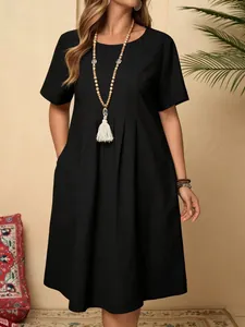 Robe classique en coton et lin noir avec plis devant et poches latérales.
