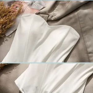 Macro detail view of a white boned corset tube top showing body-sculpting fishbone design