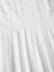 Vue macro d'un tissu en coton et lin blanc avec des détails de plis verticaux pour robe