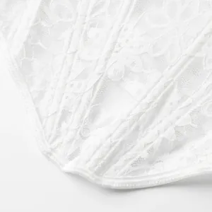 Detalle de primer plano del intrincado encaje floral blanco y malla en un corsé de mujer