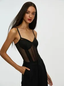 Detailed view of a sexy black sheer mesh patchwork bodysuit on a model