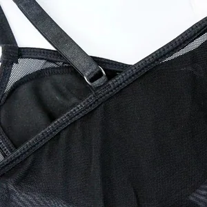 Macro view detail showing the sheer black mesh fabric and adjustable strap of a bodysuit.