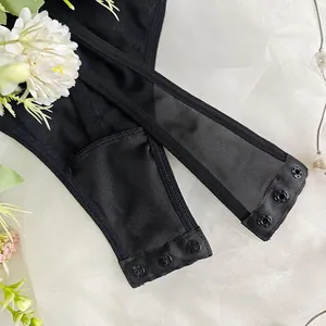 Détail d'un body sexy noir avec fermeture à trois boutons-pression et tissu en maille