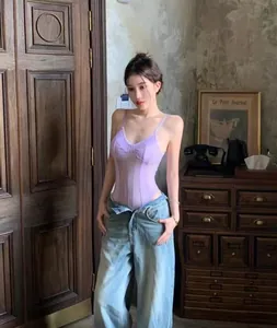 Full-length view of a lavender sheer mesh bodysuit styled with denim jeans.