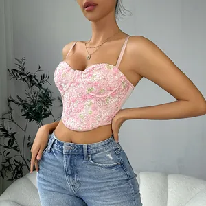 Close-up detail of a pink floral lace textured camisole top with corset-style curved hem