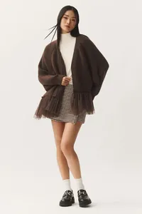 Brown knit cardigan with mesh ruffle hem, styled with a white turtleneck and skirt