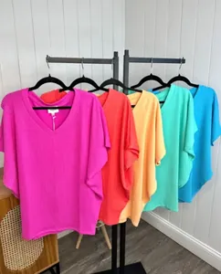 Collection of vibrant V-neck ribbed T-shirts in multiple colors on a clothing rack.