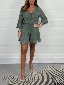 Full view of a sage green lace two-piece set on a model in a studio setting.