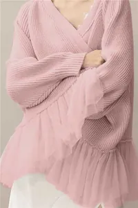 Detail showing the layered tulle ruffles and knit texture of a pink long sleeve sweater