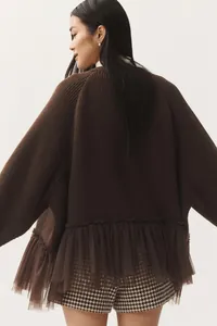 Detailed back view of a brown knit sweater featuring a stylish mesh ruffle hem and soft texture
