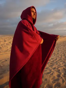 Poncho con cappuccio in pile bordeaux oversize per uomo e donna nel tramonto del deserto