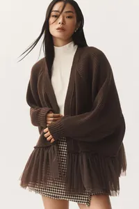 Detail view of dark brown knit cardigan featuring a tulle ruffle hem and ribbed cuffs