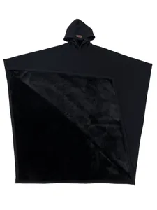 Dettaglio di un poncho nero con cappuccio che mostra la morbida fodera in ecopelliccia