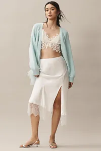 Stylish light blue knit cardigan paired with a white lace bralette and satin skirt