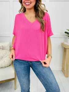 Detailed view of pink ribbed V-neck T-shirt showing texture and relaxed fit