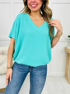 Close-up detail of a turquoise V-neck ribbed short-sleeve T-shirt in a relaxed fit.