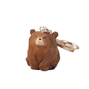 Handgeschnitzter Holzbär-Schlüsselanhänger mit süßer Sitzhaltung und goldenem Metallring